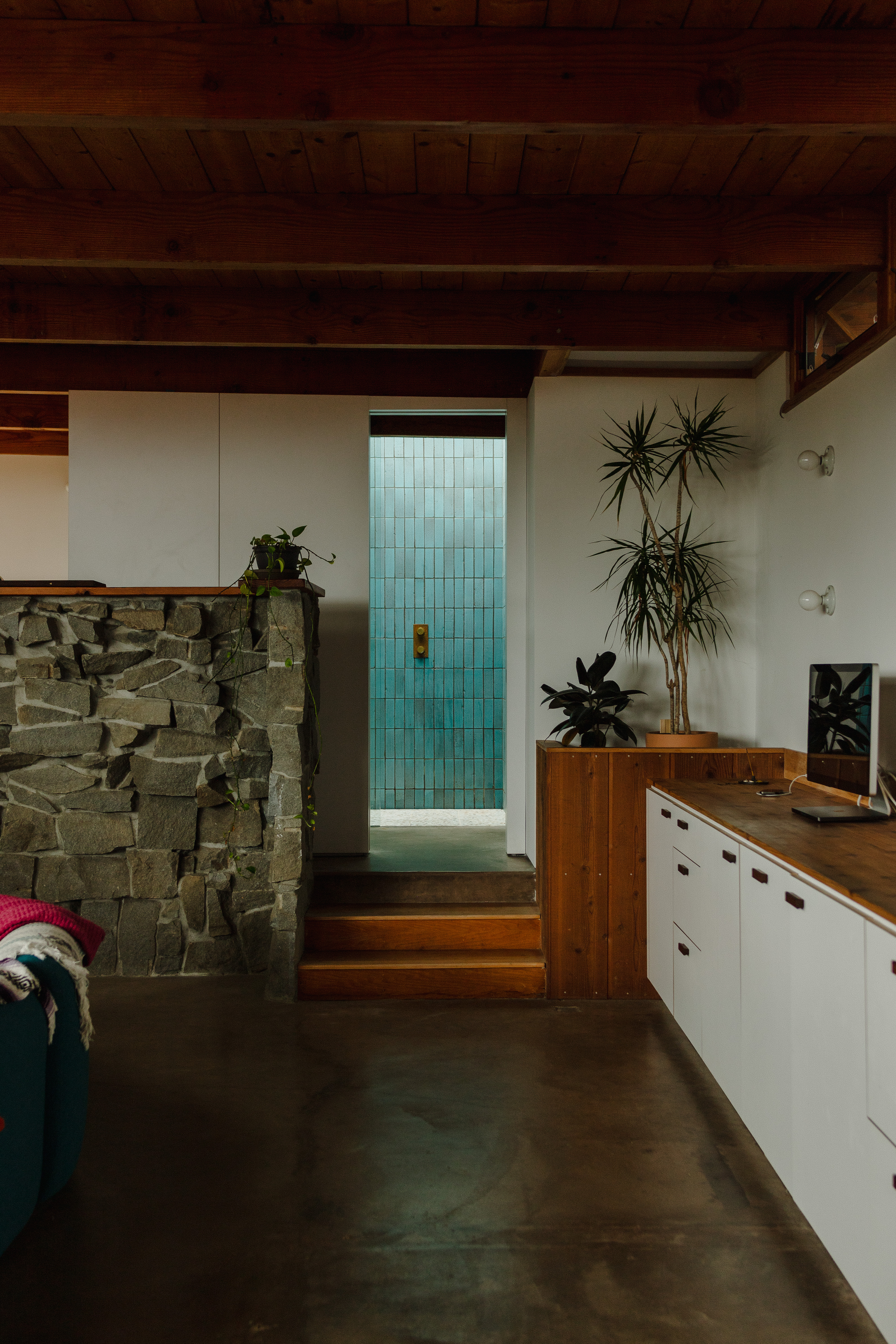 Interior with stone wall and teal glass door