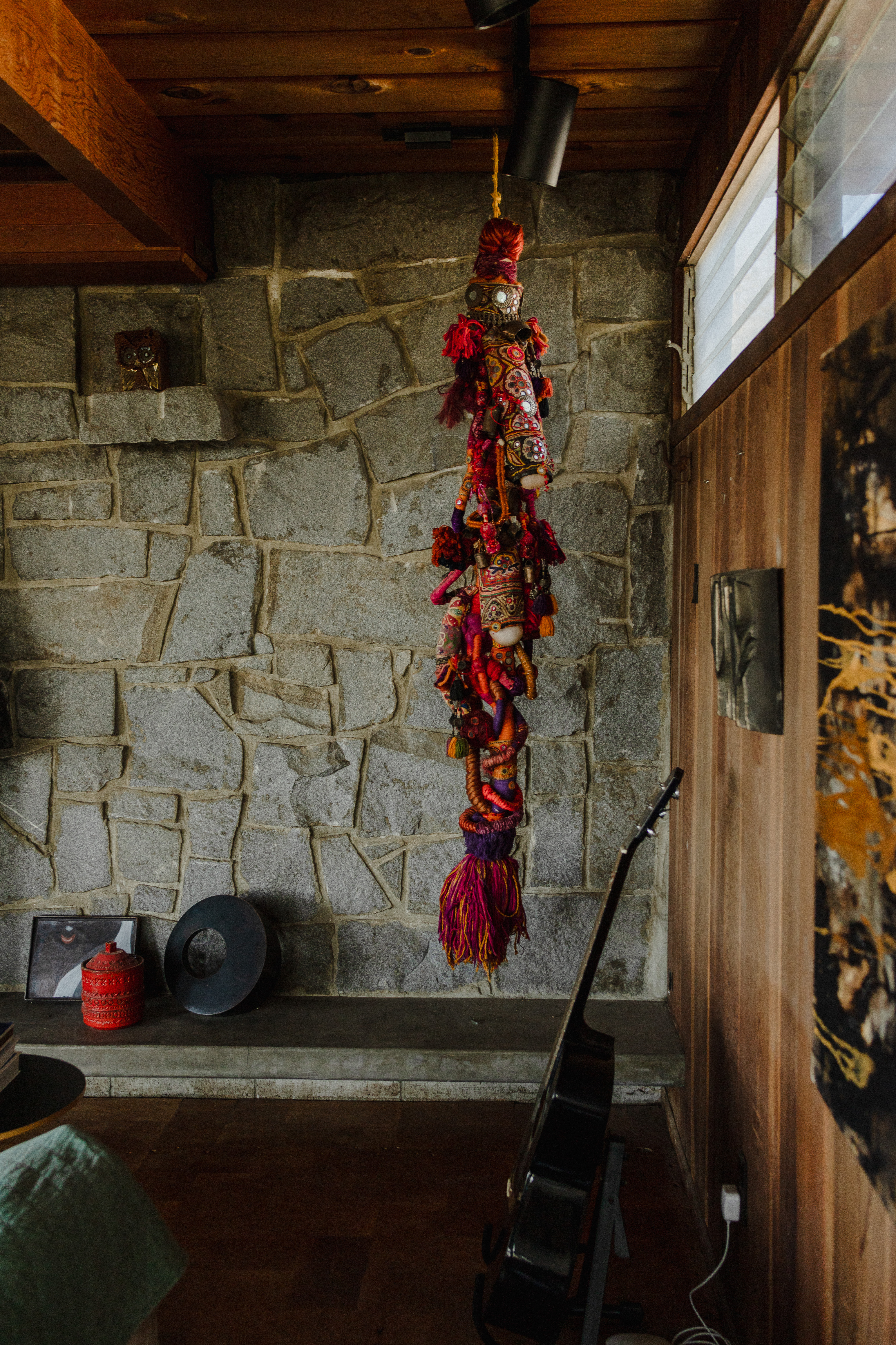 Textile art on stone wall with guitar
